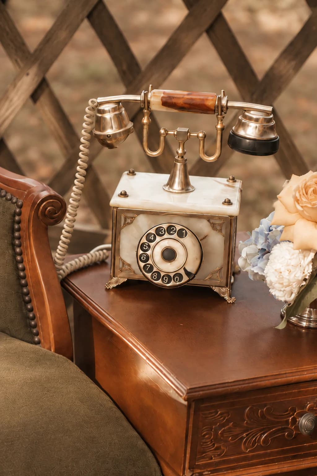Téléphone livre d’or audio ancien mis en scène sur une table près d’un fauteuil vintage