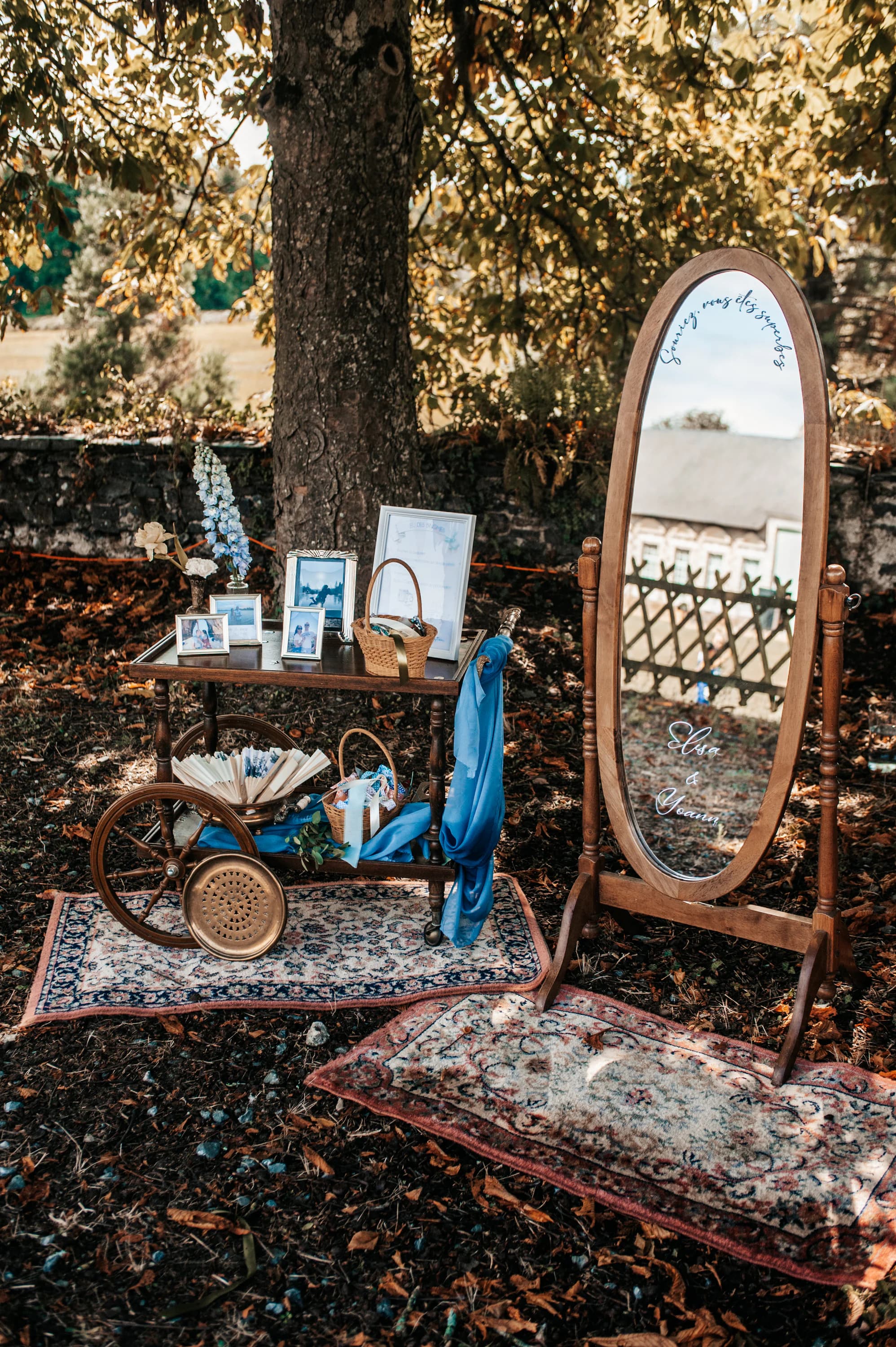 Desserte et grand miroir en bois installés sous un arbre pour un mariage